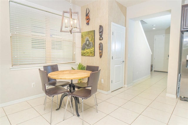 dining space with a chandelier, baseboards, and light tile patterned floors