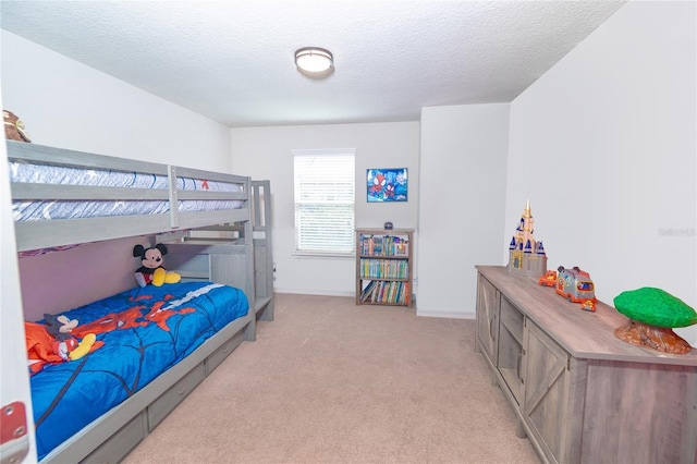 bedroom featuring light carpet, a textured ceiling, and baseboards