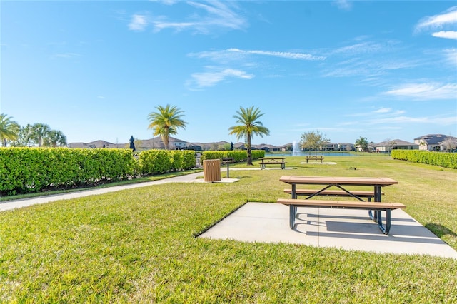 view of community with a lawn, a residential view, and a water view