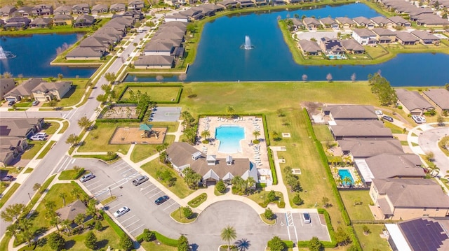 aerial view of residential area with a nearby body of water and a pool area