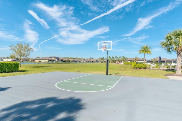 view of basketball court featuring a residential view, community basketball court, and a lawn
