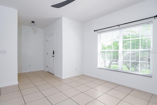 unfurnished room with light tile patterned floors, baseboards, and ceiling fan