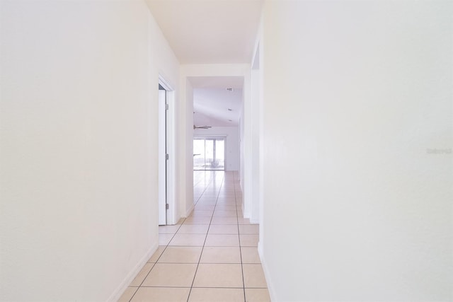 hallway featuring light tile patterned floors and baseboards