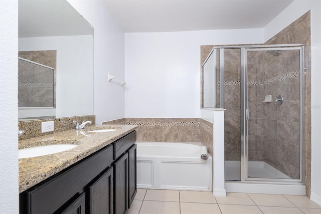 full bathroom with a sink, a garden tub, a shower stall, and tile patterned flooring