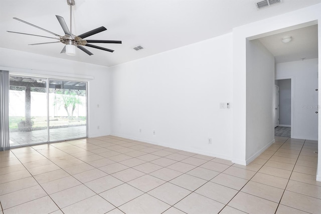 spare room featuring light tile patterned floors, visible vents, and a ceiling fan