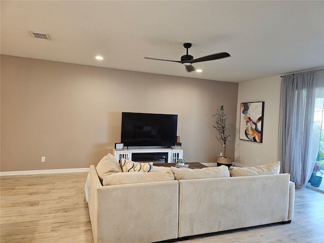 living room with light wood-type flooring, visible vents, baseboards, and recessed lighting