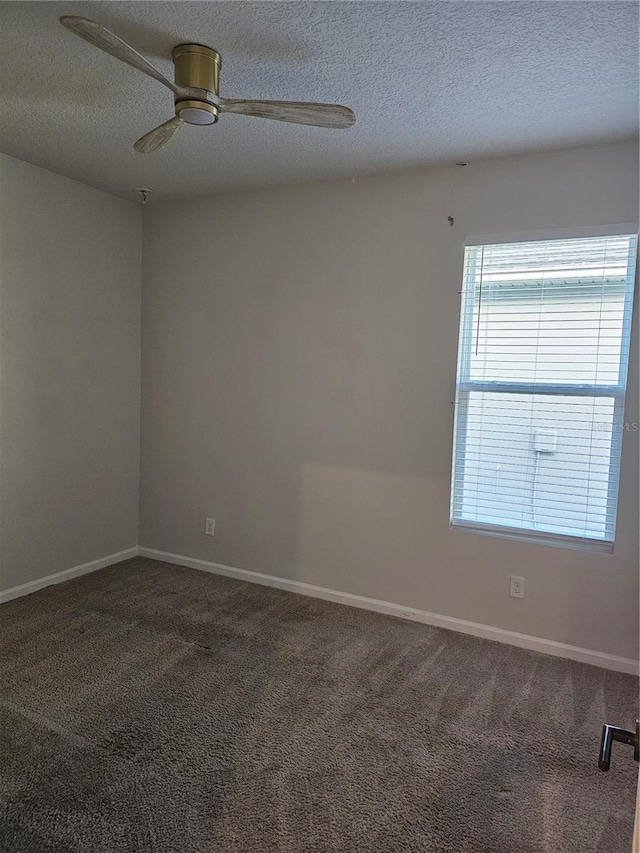 carpeted spare room with baseboards, a textured ceiling, and ceiling fan