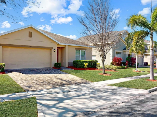 ranch-style house with decorative driveway, roof with shingles, stucco siding, a front yard, and a garage