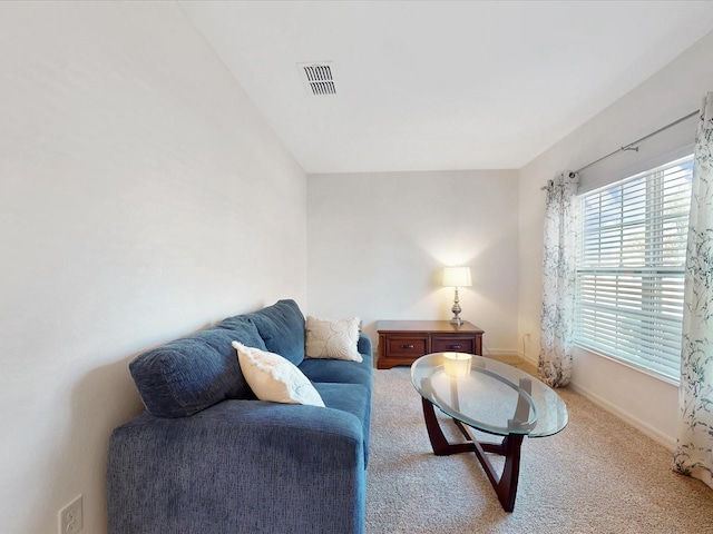 living room with carpet, visible vents, and baseboards