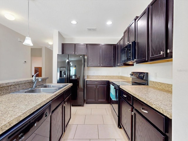 kitchen featuring light countertops, visible vents, dark brown cabinetry, a sink, and black appliances