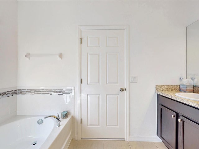 full bath featuring a garden tub, vanity, and tile patterned floors