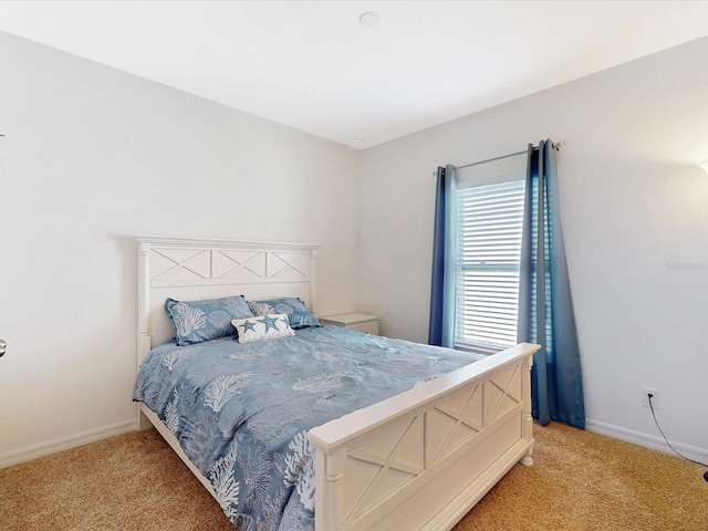 bedroom featuring light colored carpet and baseboards