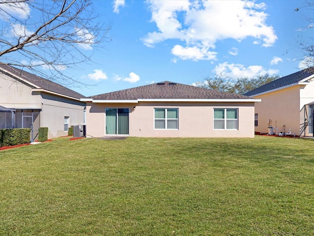 rear view of property with a lawn, central AC unit, and stucco siding