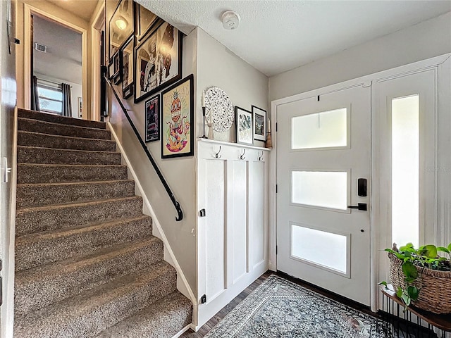 entryway featuring stairway and a textured ceiling