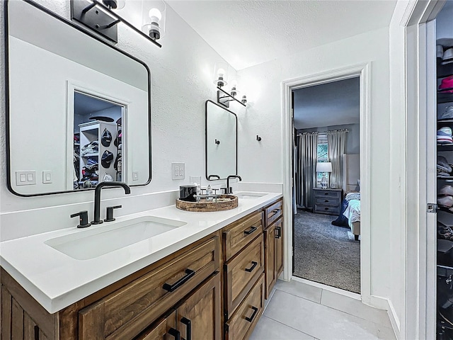 full bath with tile patterned flooring, a sink, a spacious closet, and double vanity