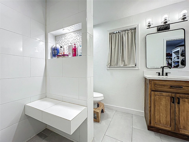 bathroom featuring toilet, baseboards, vanity, and tile patterned floors