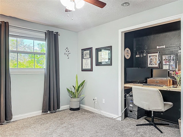 carpeted home office featuring a ceiling fan, a textured ceiling, and baseboards