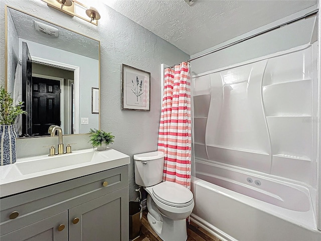 bathroom with a textured wall, vanity, toilet, and a textured ceiling