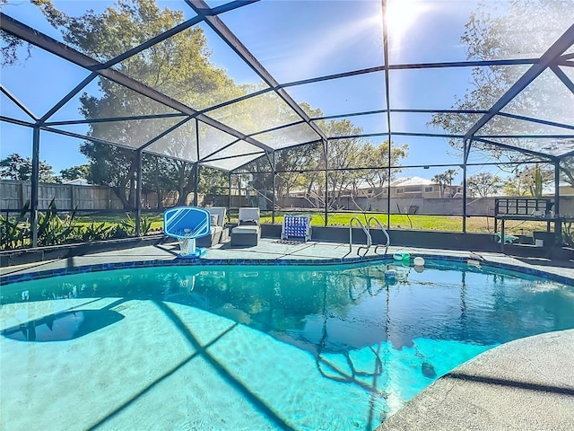 pool with glass enclosure, a patio area, and fence