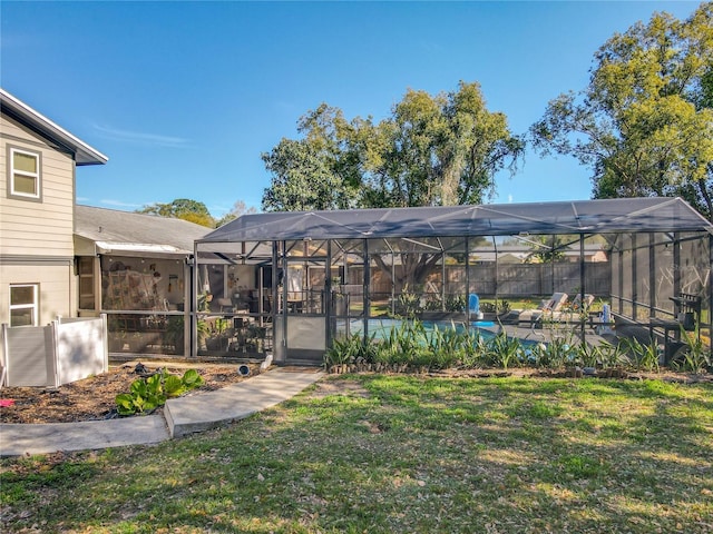 view of yard featuring glass enclosure and a fenced in pool