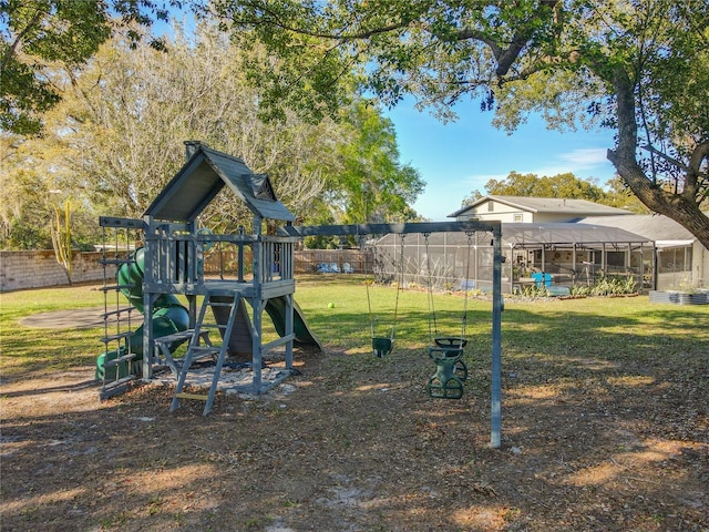 view of play area with a lanai, a lawn, and fence