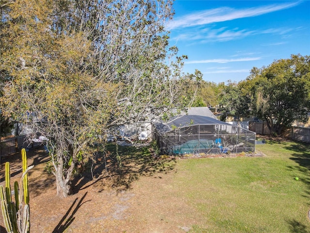 view of yard with a fenced backyard and a lanai