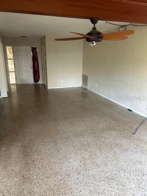 unfurnished room featuring speckled floor, visible vents, beamed ceiling, and a ceiling fan