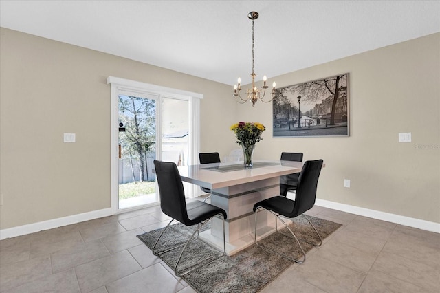 tiled dining room featuring a notable chandelier and baseboards