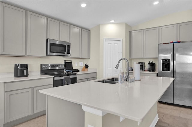 kitchen with a center island with sink, gray cabinets, appliances with stainless steel finishes, and a sink