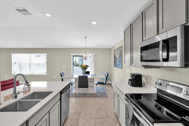 kitchen with a sink, visible vents, appliances with stainless steel finishes, and gray cabinetry