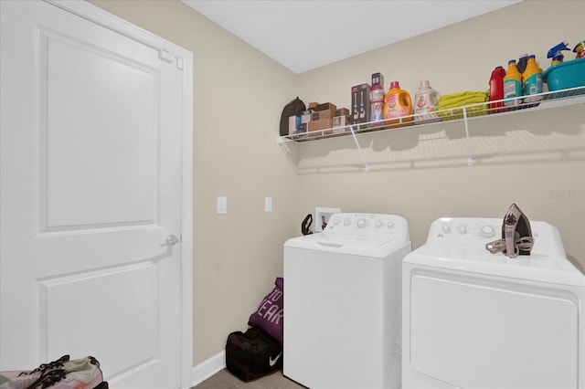 clothes washing area with washer and dryer, laundry area, and baseboards