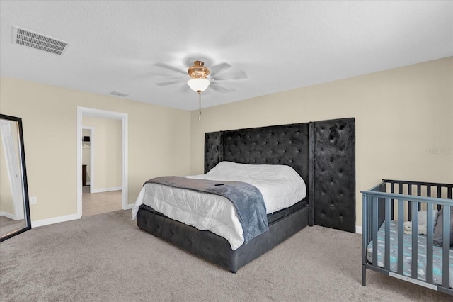 carpeted bedroom with a ceiling fan, baseboards, and visible vents