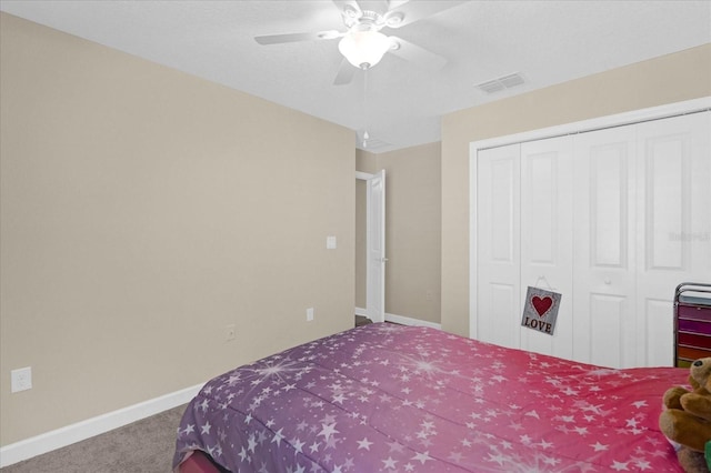 carpeted bedroom featuring a ceiling fan, baseboards, visible vents, and a closet