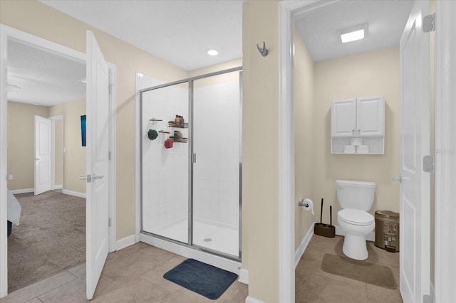 full bath featuring tile patterned floors, a shower stall, toilet, and baseboards