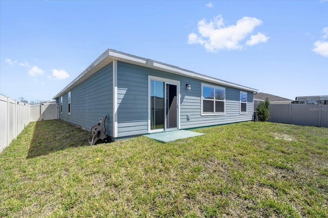 back of property with a lawn and a fenced backyard