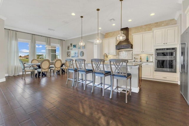 kitchen featuring stainless steel appliances, a kitchen breakfast bar, custom exhaust hood, and dark wood-type flooring