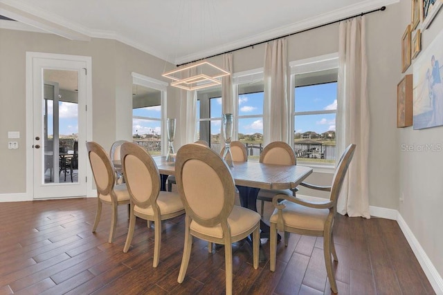 dining area featuring an inviting chandelier, dark wood-type flooring, baseboards, and ornamental molding