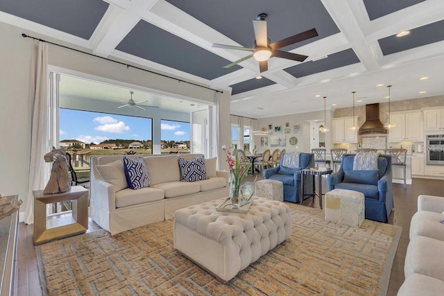 living room with beam ceiling, wood finished floors, coffered ceiling, and ceiling fan