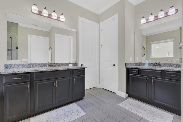 full bath featuring a sink, two vanities, and crown molding