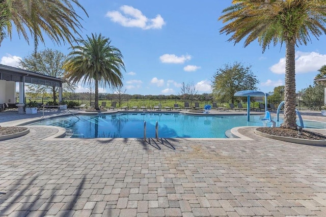 community pool featuring a patio and fence