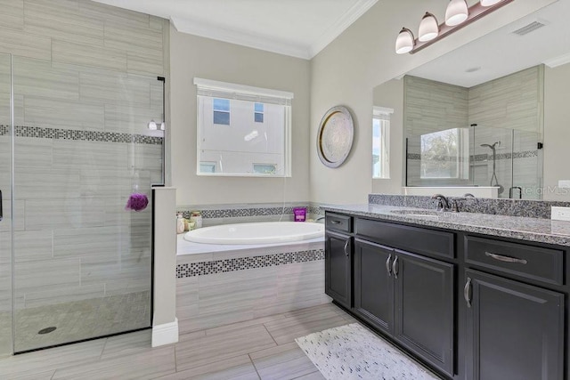 bathroom featuring vanity, visible vents, a stall shower, ornamental molding, and a bath