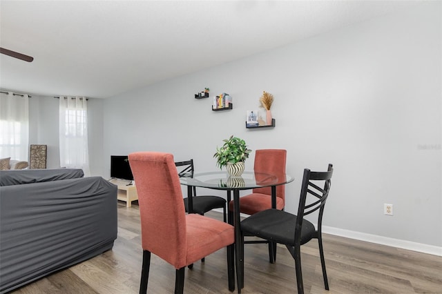 dining space featuring ceiling fan, light wood finished floors, and baseboards