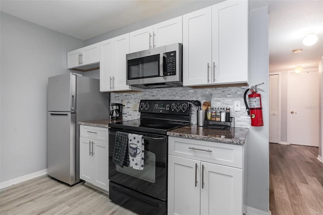 kitchen with appliances with stainless steel finishes, backsplash, and white cabinets