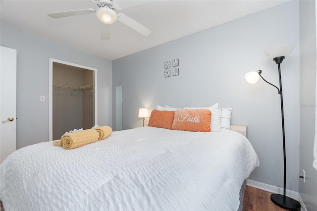 bedroom featuring ceiling fan, a closet, wood finished floors, and baseboards