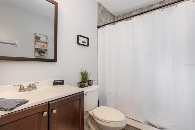 full bathroom featuring toilet, curtained shower, and vanity