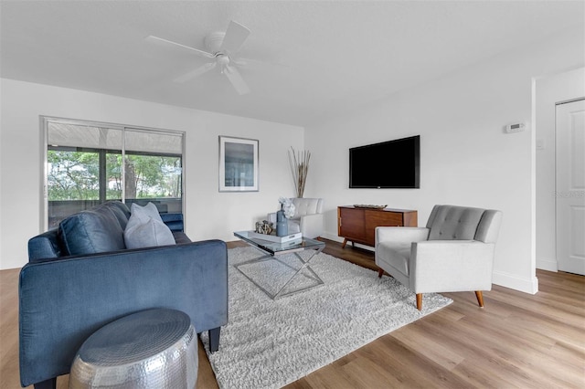 living room with baseboards, a ceiling fan, and wood finished floors