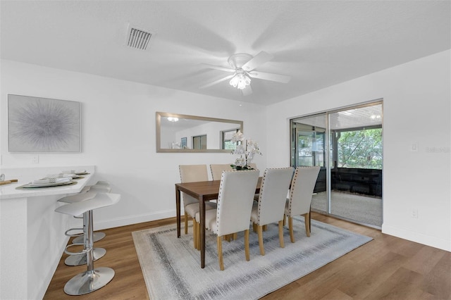 dining space featuring visible vents, baseboards, and wood finished floors