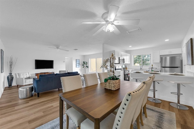 dining area featuring recessed lighting, light wood-style floors, ceiling fan, and a textured ceiling