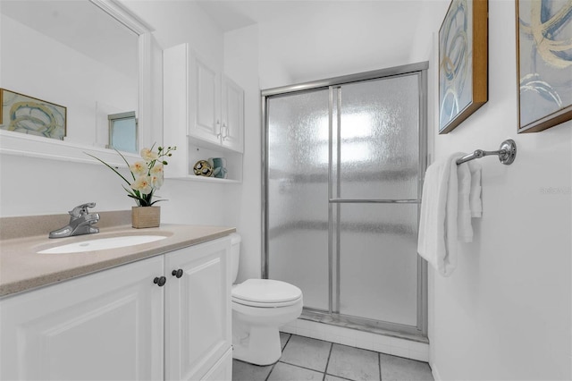 bathroom with vanity, toilet, a shower stall, and tile patterned flooring