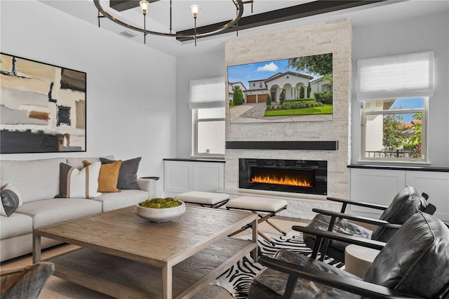 8025 Topsail Pl, Winter Garden, FL 34787 - living room featuring a stone fireplace, a chandelier, and wood finished floors